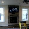 During the construction of this home we framed out a pocket below the TV for the center speakers. Due to the thin 55" LED the center speaker disapears into the stone wall without taking up room on the mantel