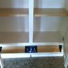 Upper Cabinet opened to show the natural wood color of the shelving inside. 