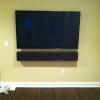 Notice the custom speakers not only matches the dimensions of the 65" TV but is designed to match the wood beams on the ceiling and stained to match.